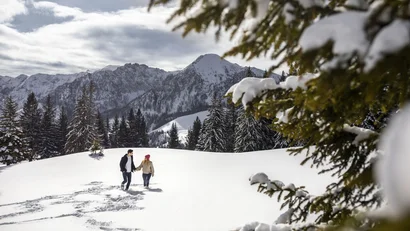 Paar geht im schneebedeckten Gebirge spazieren