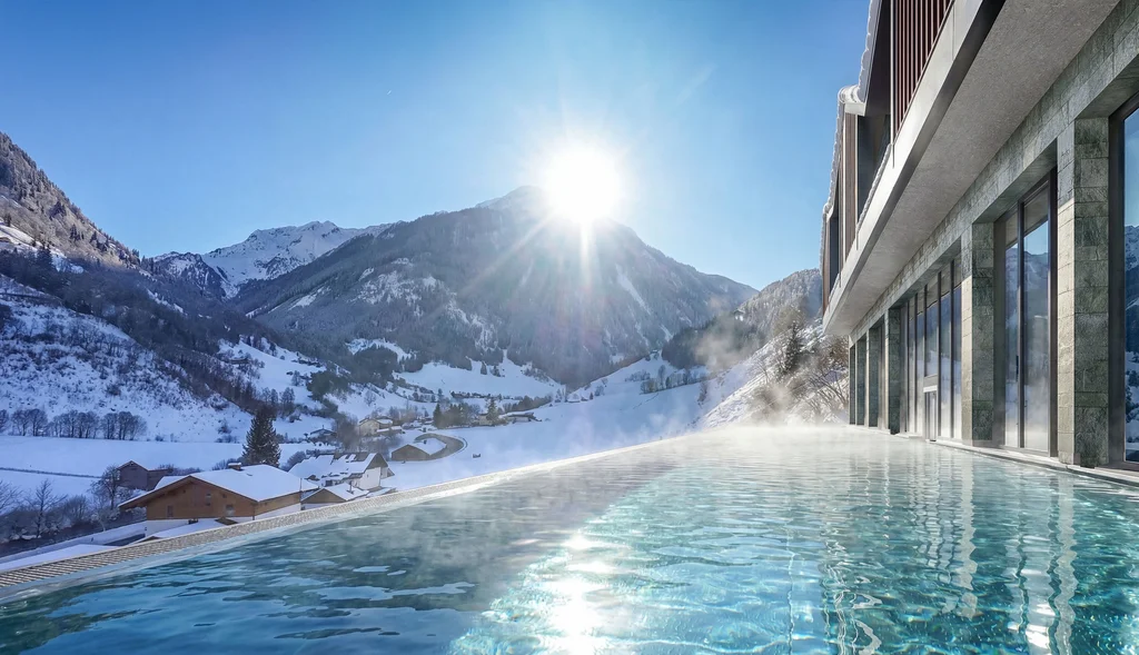 Infinity-Pool mit Blick auf schneebedeckte Berge und sonnigen Himmel