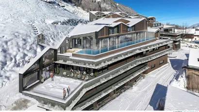 Modernes Hotel mit Dachpool in schneebedeckter Berglandschaft